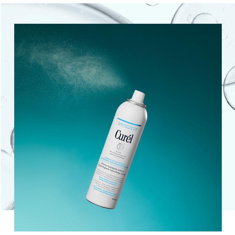 Weiße Sprühflasche mit hellblauem Deckel, sprüht. Aufschrift: Curel, Hydratation Intense, Feuchtigkeits-Tiefenpflege Spray.