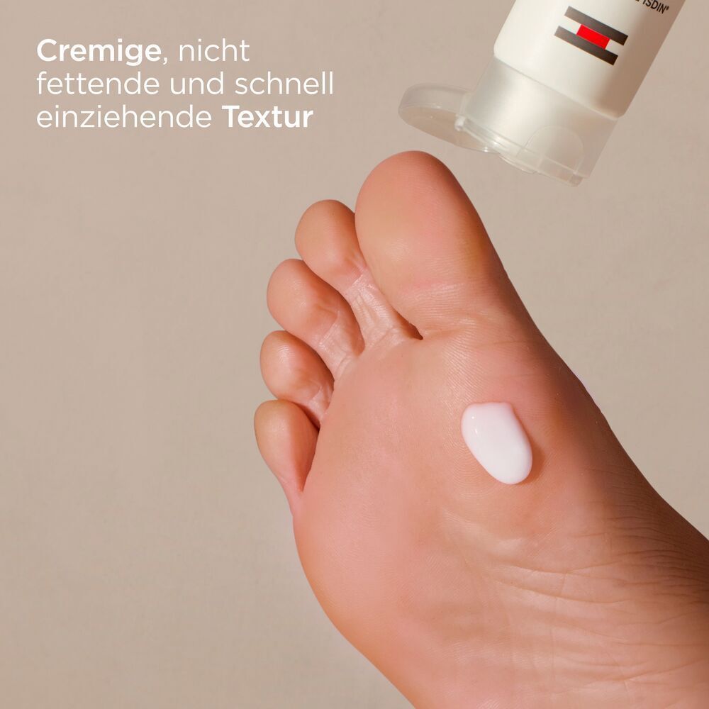 Creme auf Fuß. Text: Cremige, nicht fettende und schnell einziehende Textur.
