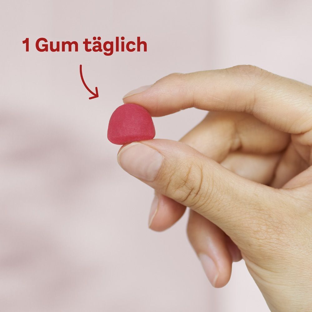 Hand hält ein rotes Gummibärchen. Text: 1 Gum täglich.