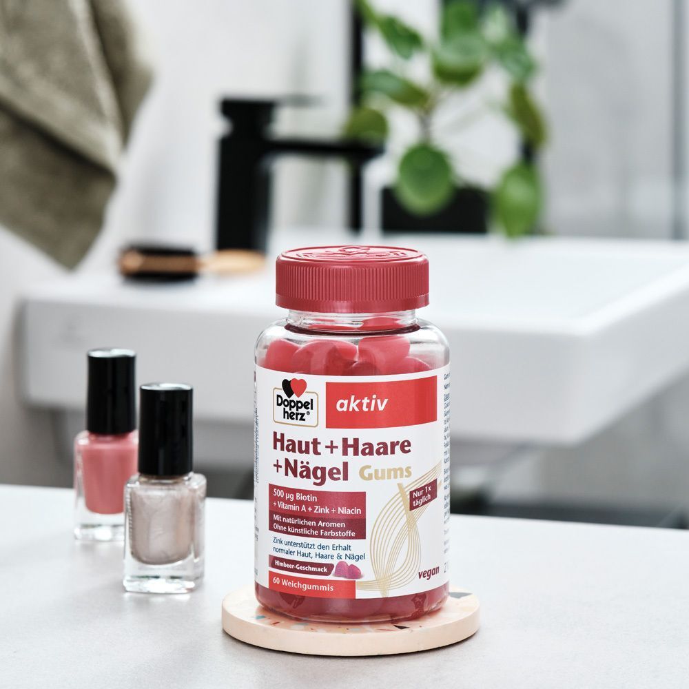Flasche Doppelherz aktiv Haut + Haare + Nägel Gums auf Untersetzer. Nagellack daneben.