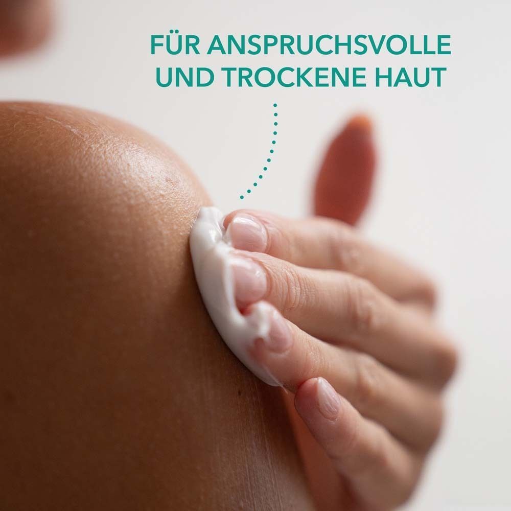 Hand trägt Creme auf Schulter auf. Text: Für anspruchsvolle und trockene Haut.