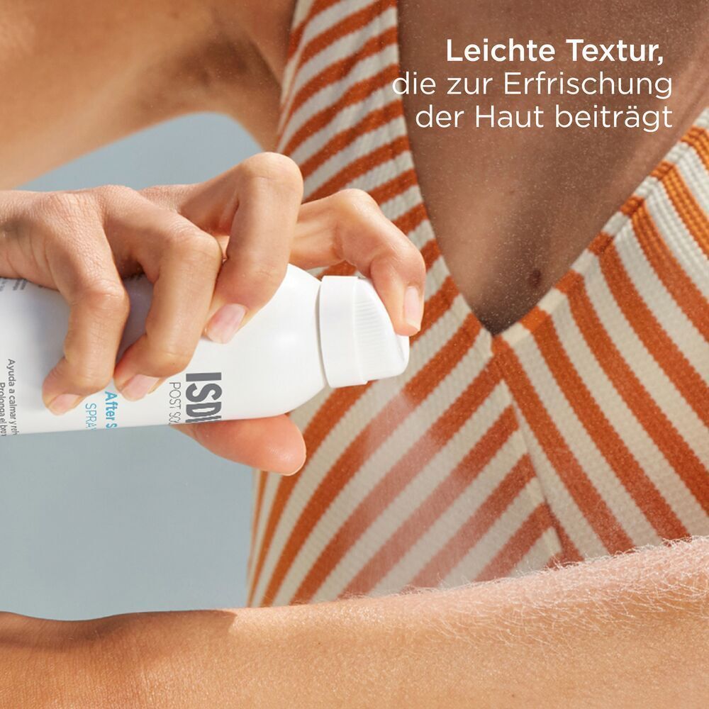 Hand sprüht auf Arm. Weiße Sprühflasche mit blauem Boden. Aufschrift: ISDIN POST SOLAR After Sun SPRAY.