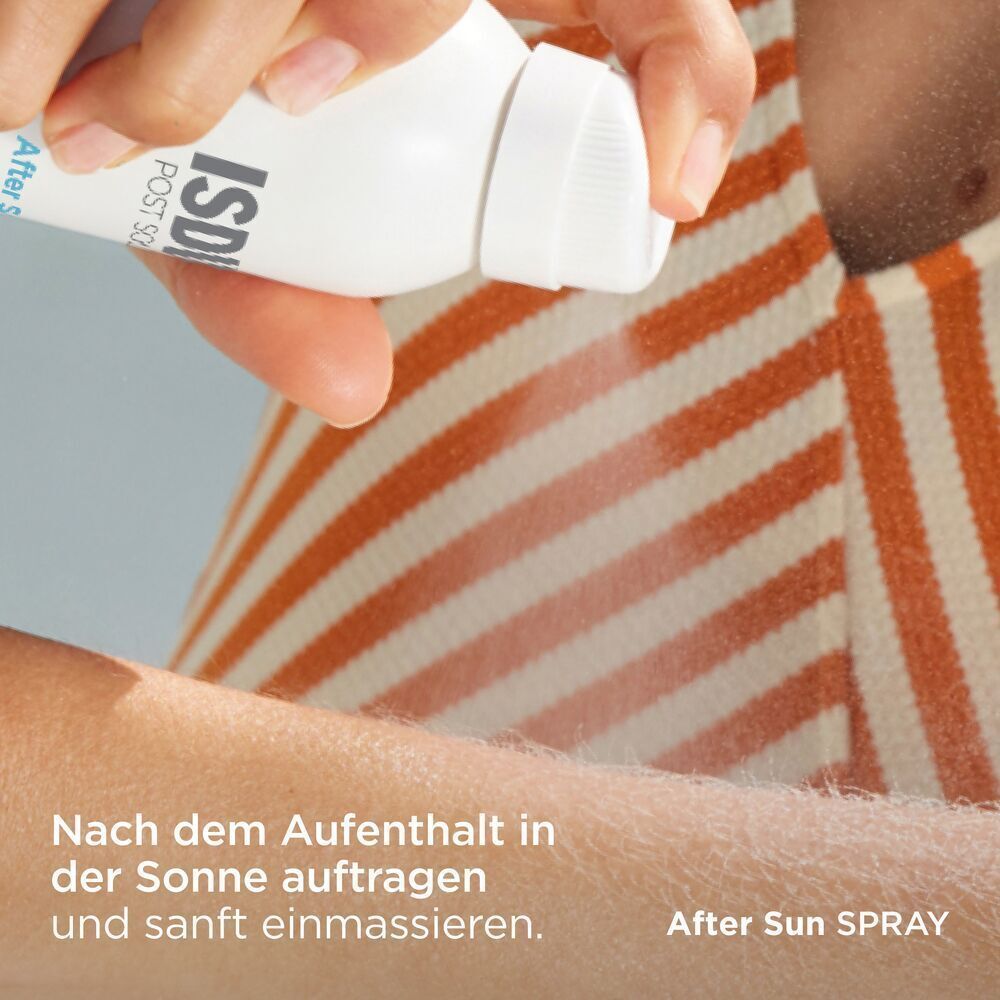 Hand sprüht auf Arm. Weiße Sprühflasche mit blauem Boden. Aufschrift: ISDIN POST SOLAR After Sun SPRAY.