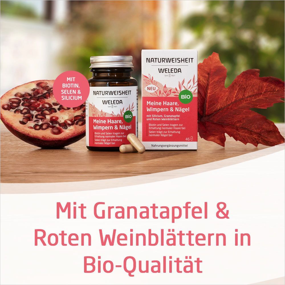 Flasche und Schachtel neben Granatapfel und Blättern. Text: Mit Granatapfel & Roten Weinblättern in Bio-Qualität.