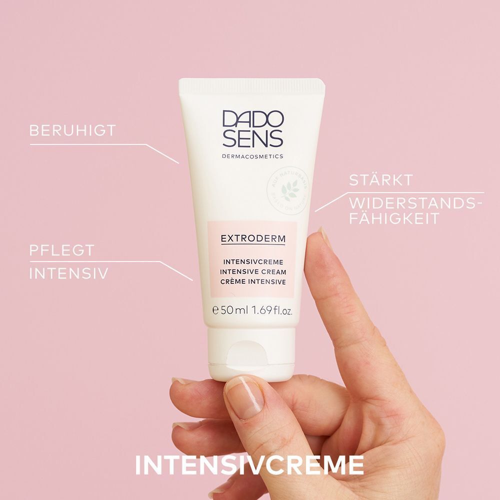 Hand hält eine Tube DADO SENS Extroderm Intensivcreme mit deutschen Textangaben.