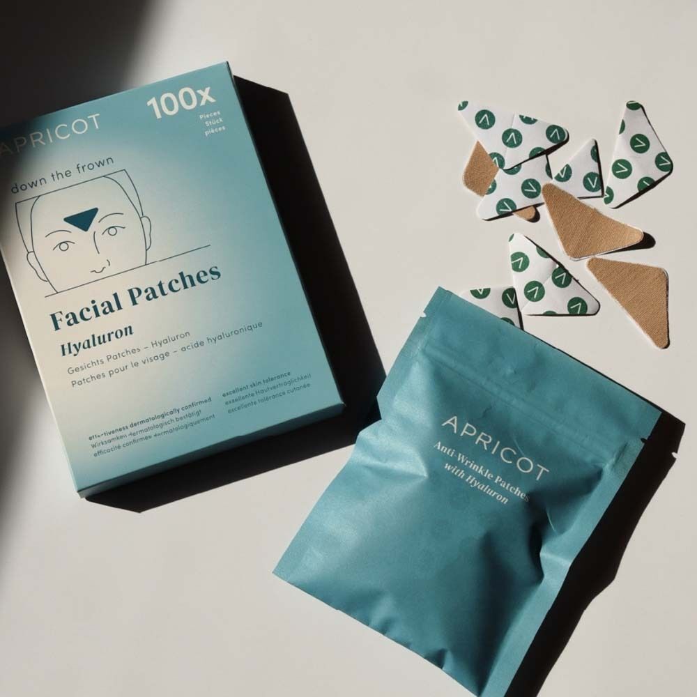 Packung und Beutel mit Gesichtspflastern. Aufdruck: APRICOT, Facial Patches Hyaluron. Daneben Pflaster.