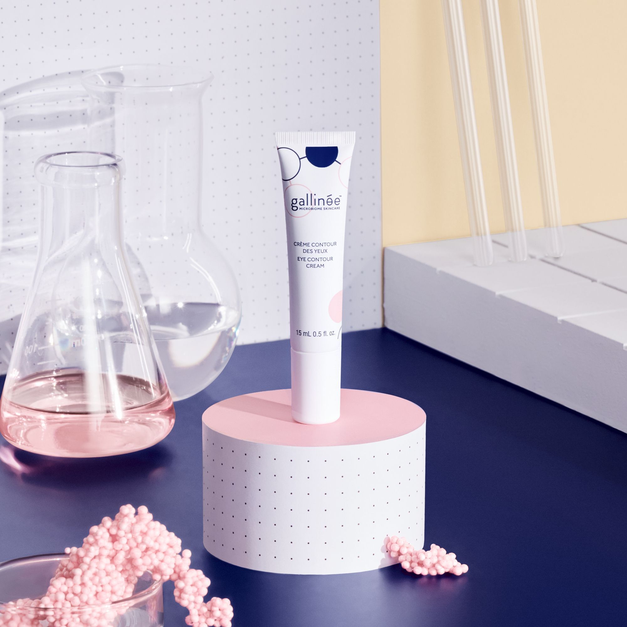 GA EYE CONTOUR CREAM auf rosa Podest. Labor-Hintergrund mit Glasbehältern und Reagenzgläsern.