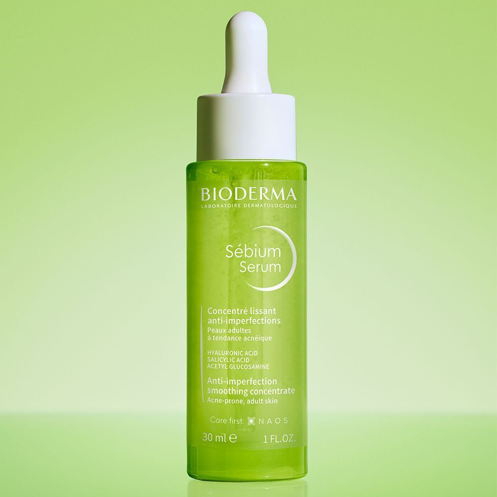 Grüne Flasche mit weißem Deckel. Aufschrift: BIODERMA, Sébium Serum. Anti-Unreinheiten, glättendes Konzentrat. 30 ml.