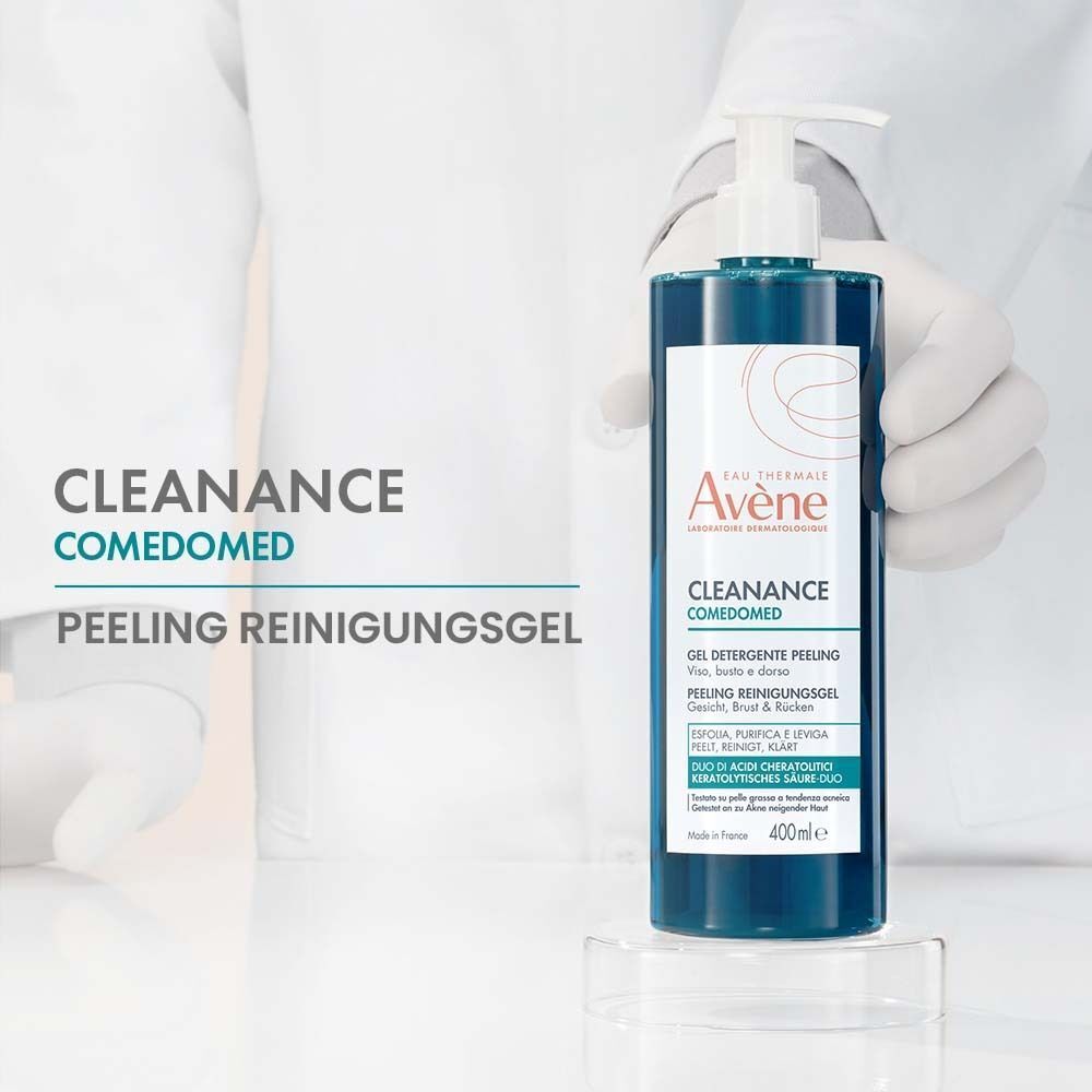 AVENE Cleanance Comedomed Peeling Reinigungsgel. Blaue Flüssigkeit in transparenter Flasche mit Pumpverschluss. Auf Glasplatte. Hintergrund: weiß.