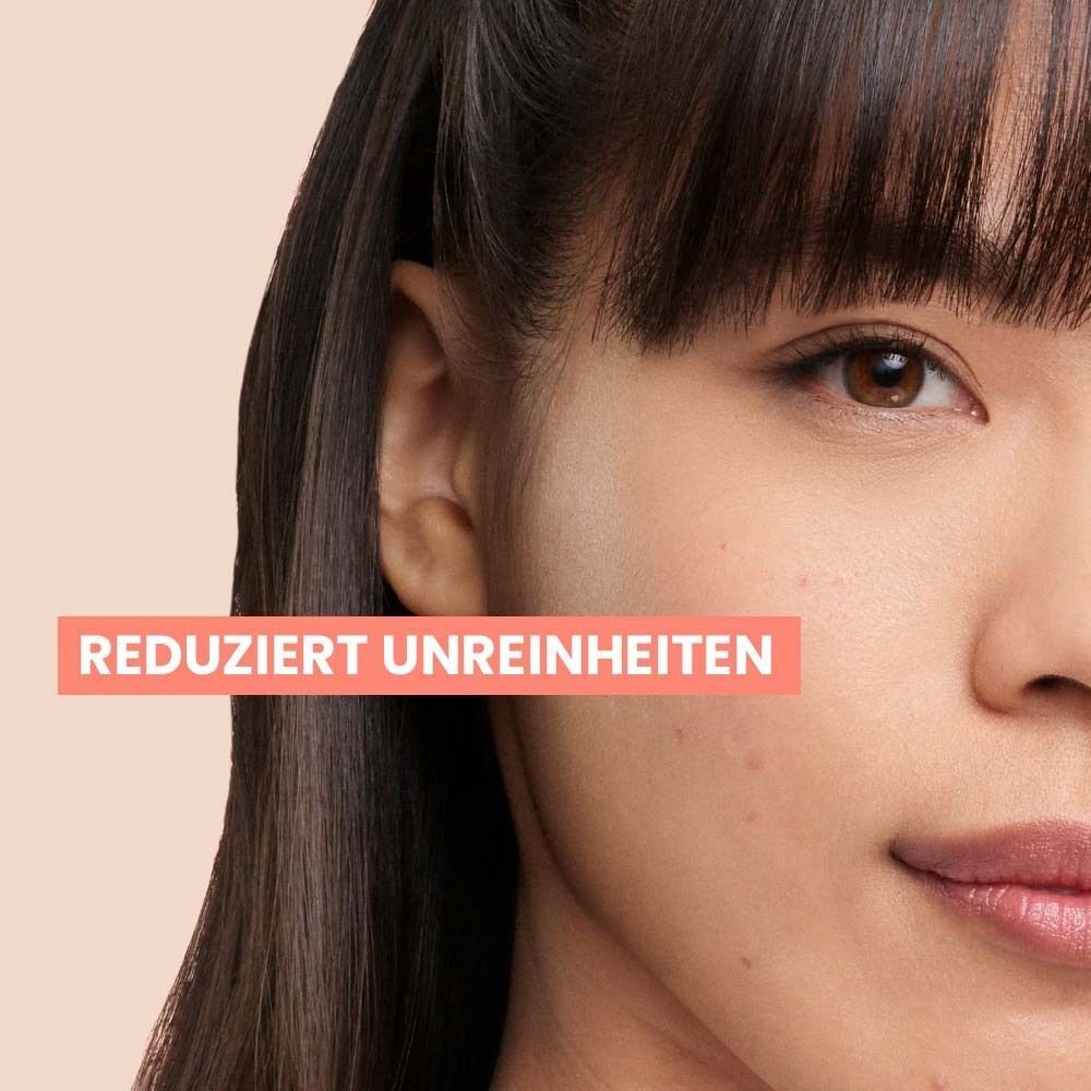 Gesicht einer Frau. Text: Reduziert Unreinheiten. Hintergrund: hell.