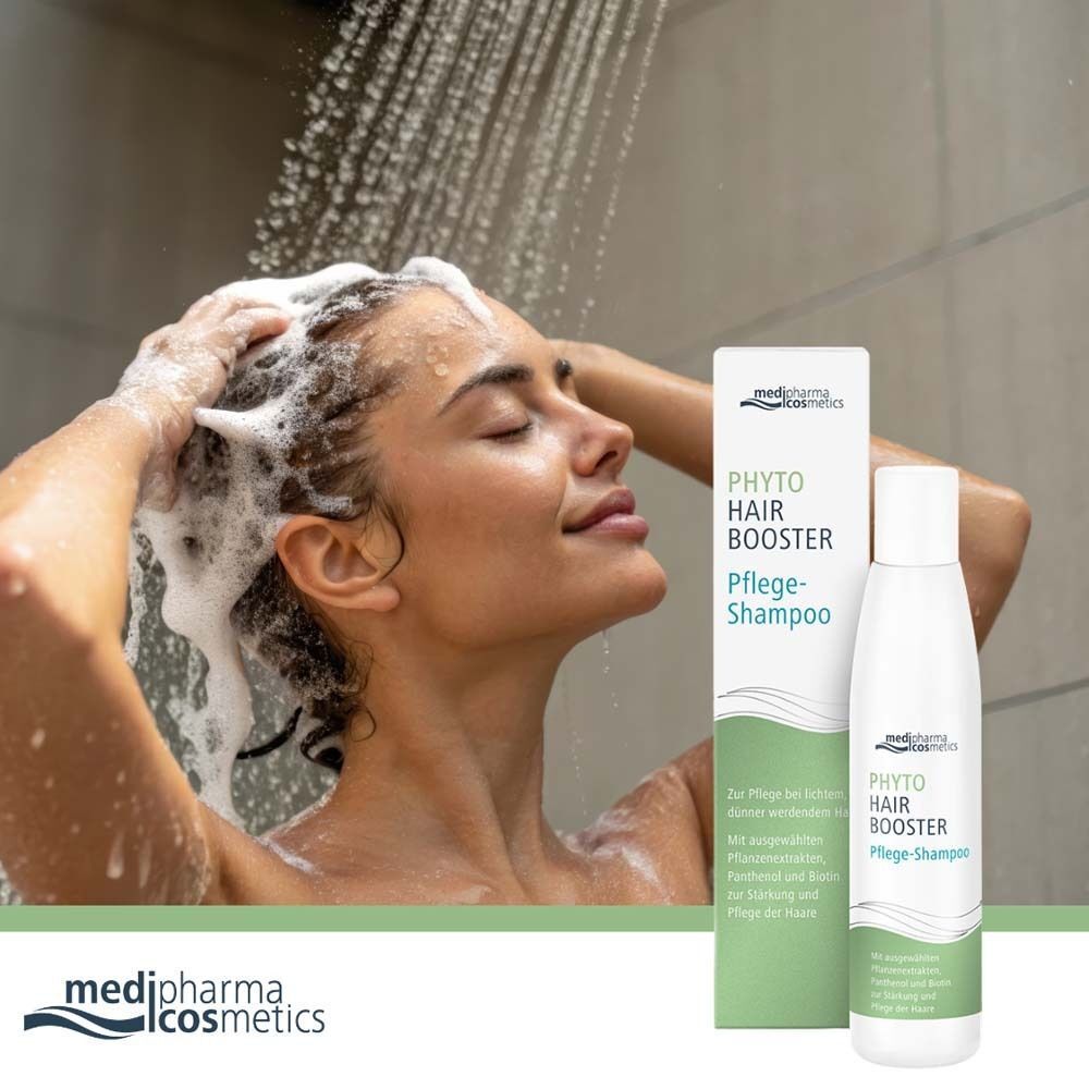 Eine Frau wäscht sich die Haare unter der Dusche. Neben ihr steht eine Flasche PHYTO HAIR Booster Pflege-Shampoo.