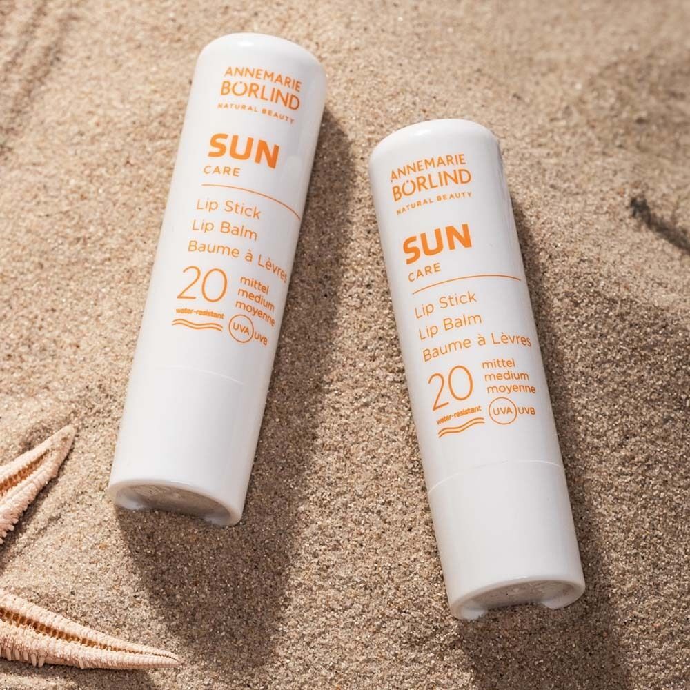 Zwei ANNEMARIE BÖRLIND SUN CARE Lippenstifte LSF 20 auf Sand mit Seestern.