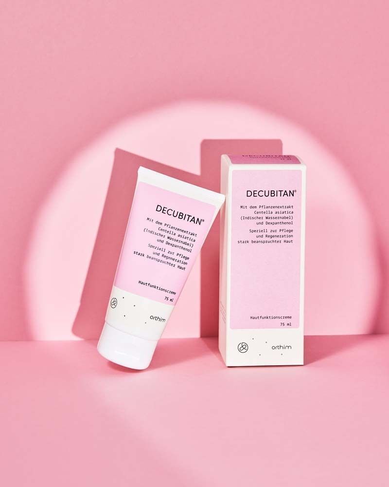 Hautfunktionscreme-Tube und Verpackung auf rosa Hintergrund. Tube und Verpackung zeigen Produktnamen und Text. 75 ml.