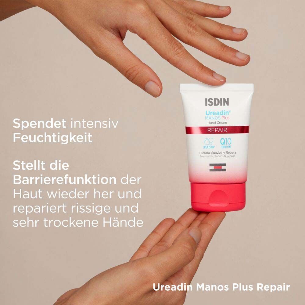 ISDIN Ureadin MANOS Plus Handcreme-Tube zwischen Händen. Weiß-rote Tube mit Produktnamen und Inhaltsstoffen. Beige Hintergrund.