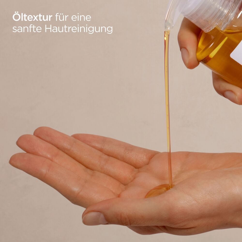Hand, die Öl aus einer Flasche in die Handfläche gießt. Gelbe Flüssigkeit.