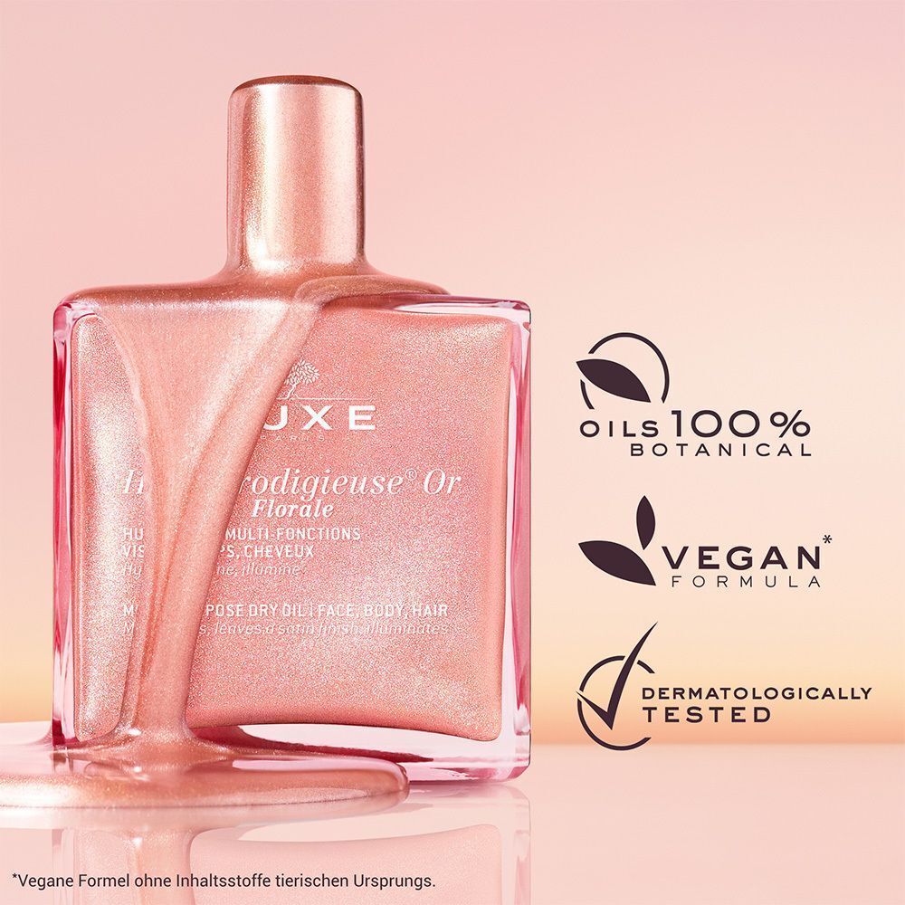 Ein Flakon mit rosafarbenem Öl. Aufschrift: Nuxe Huile Prodigieuse® Or Florale. Quadratischer Flakon mit goldenem Verschluss. Logos: 100% Botanical Oils, Vegan, Dermatologisch getestet.