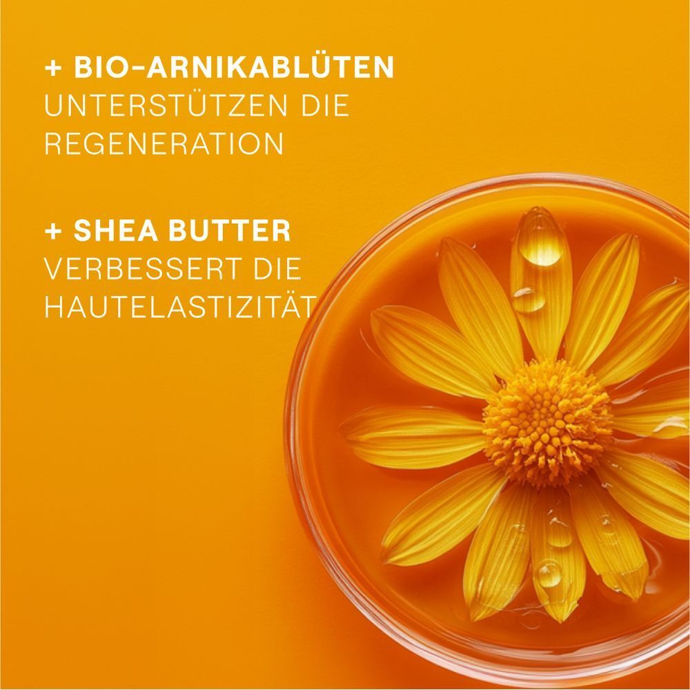Nahaufnahme einer Schale mit Flüssigkeit und einer Blüte. Text: + Bio-Arnikablüten unterstützen die Regeneration. + Sheabutter verbessert die Hautelastizität.