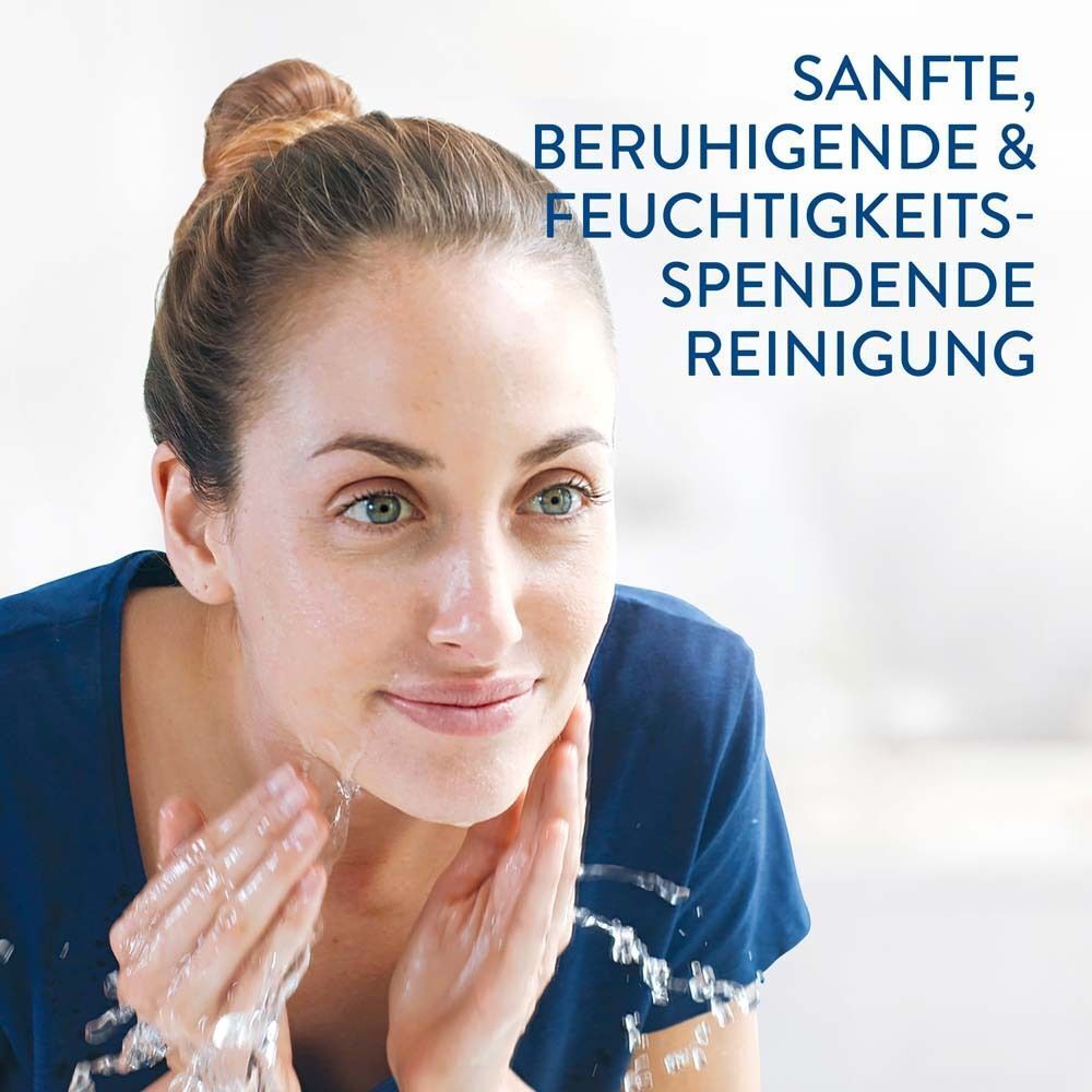 Frau wäscht ihr Gesicht mit Wasser. Text: Sanfte, beruhigende & feuchtigkeitsspendende Reinigung.