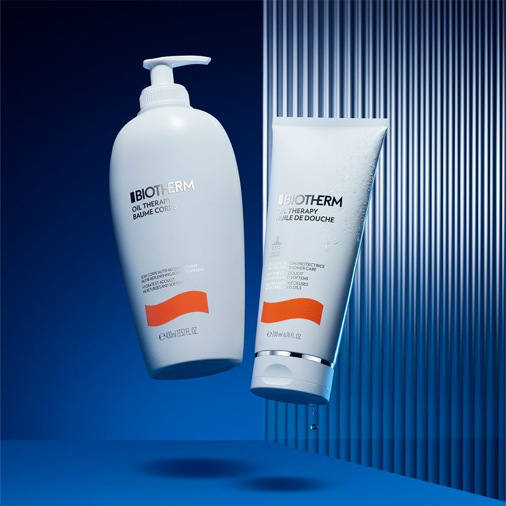 Zwei Produkte: Flasche und Tube. Aufschrift: BIOTHERM, OIL THERAPY. Orangefarbener Streifen. Blauer Hintergrund.
