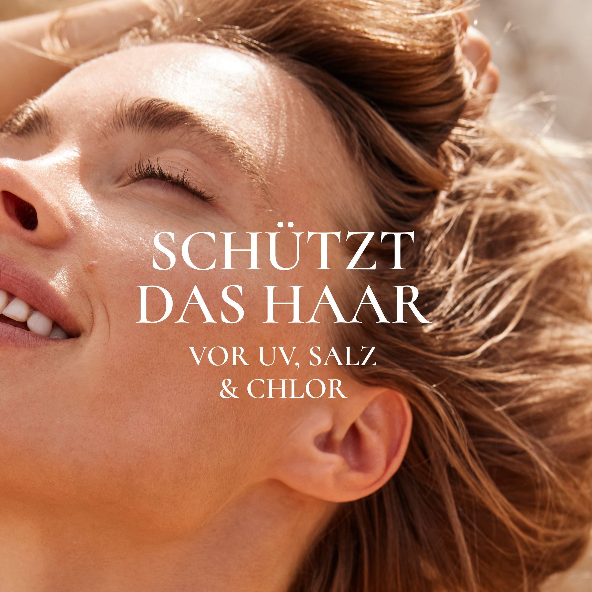 Nahaufnahme eines Gesichts. Text: Schützt das Haar vor UV, Salz & Chlor.