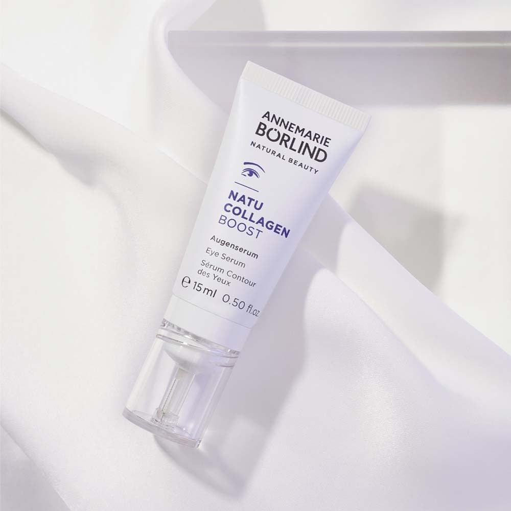 Eine Tube ANNEMARIE BÖRLIND NATUCOLLAGEN BOOST Augenserum auf weißem Stoff.