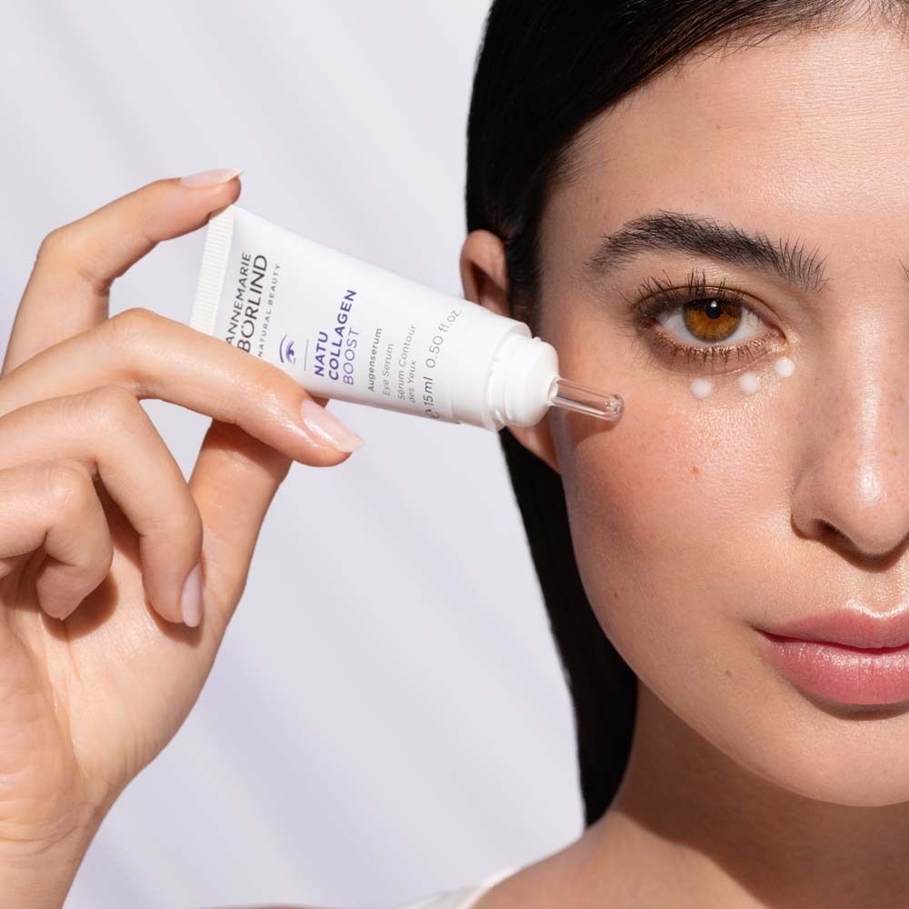 Frau trägt ANNEMARIE BÖRLIND NATUCOLLAGEN BOOST Augenserum auf.