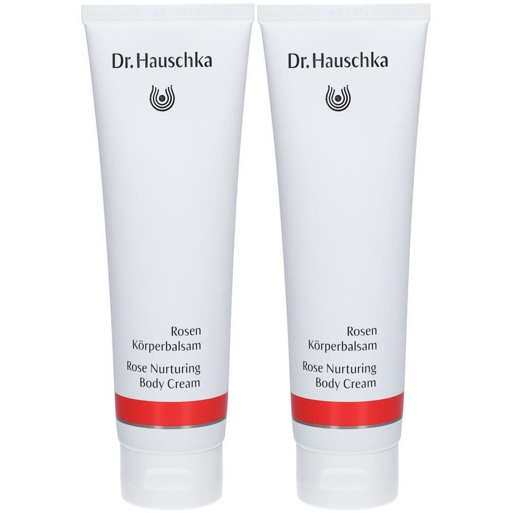 Zwei weiße Tuben Dr. Hauschka Rosen Körperbalsam mit rotem Band.