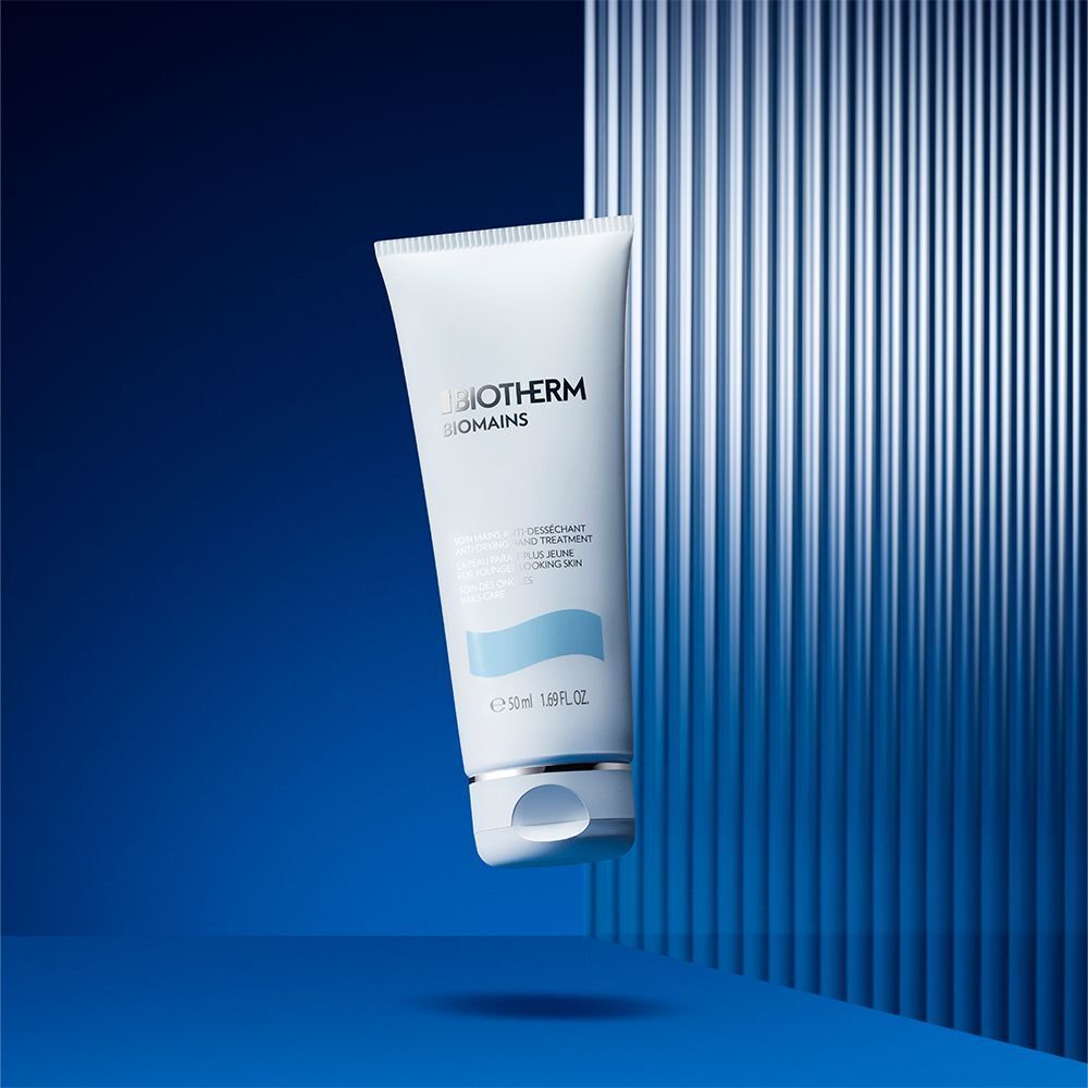 BIOTHERM Biomains Handcreme-Tube auf blauem Hintergrund. Aufschrift: Anti-Desséchant Hand Treatment, für jünger aussehende Haut, Nagelpflege.