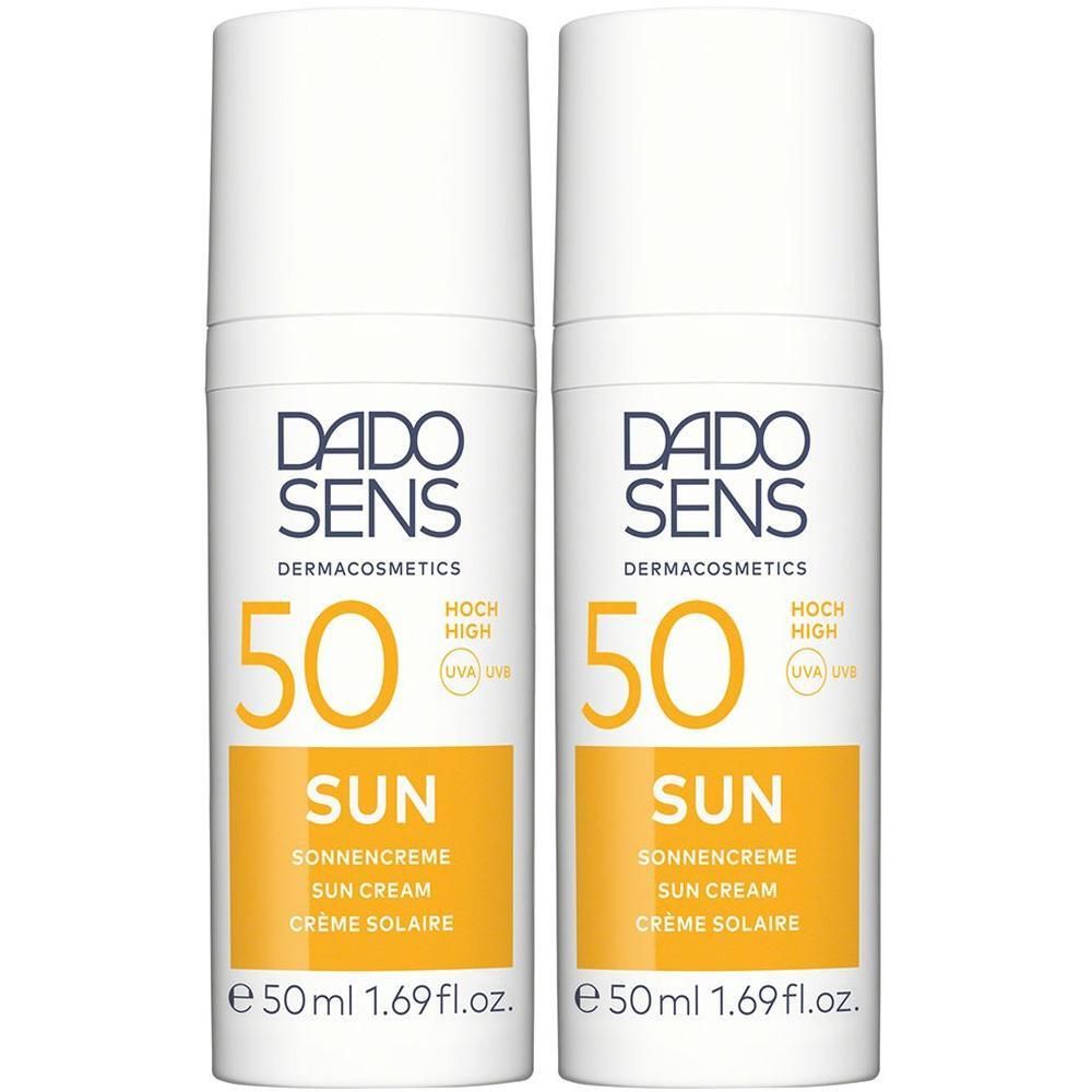 Zwei Flaschen DADO SENS Sonnencreme 50 mit Pumpspender, weiß mit orangefarbenem Etikett.