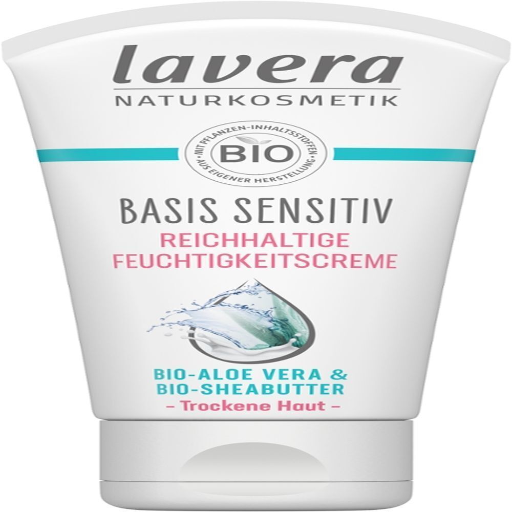 Weiße Tube mit Text: "lavera BASIS SENSITIV REICHHALTIGE FEUCHTIGKEITSCREME". Logo: Bio-Siegel. Text: "Trockene Haut".