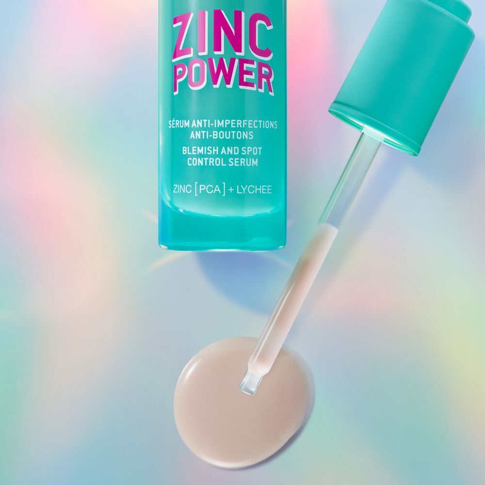Pipette mit Serum und Flasche NUXE Zinc Power Serum. Aufschrift: ZINC POWER, Serum gegen Hautunreinheiten. Helle Flüssigkeit.