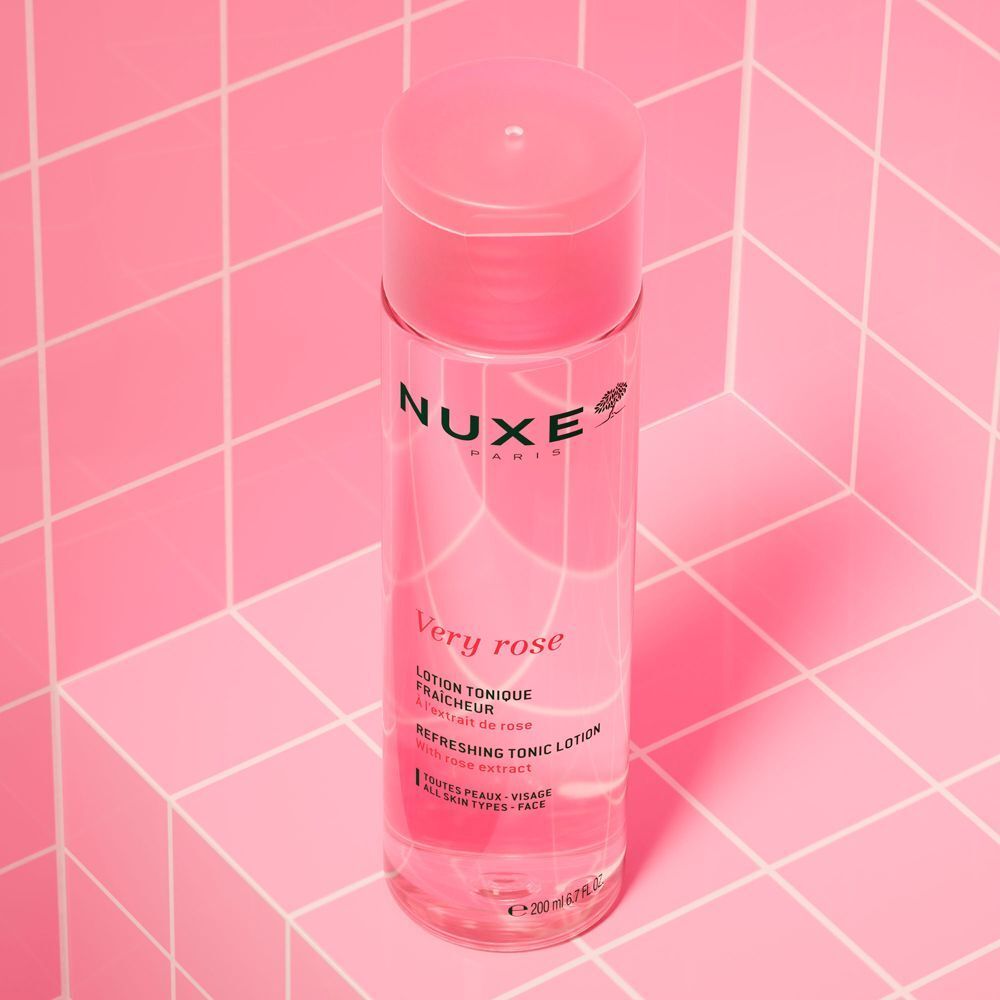 Eine Flasche NUXE Very Rose Lotion auf rosa Kacheln. Rosa Flasche mit rosa Deckel. Text: Very Rose, Lotion Tonique Fraîcheur.