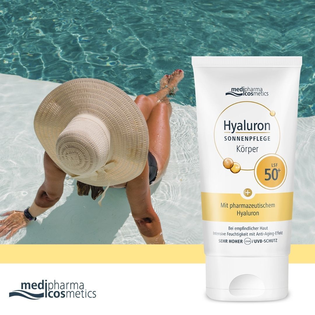 Eine Tube medipharma cosmetics Hyaluron Sonnenpflege Körper LSF 50+ neben einer Person am Pool. Weiße Tube mit gelben und blauen Elementen.