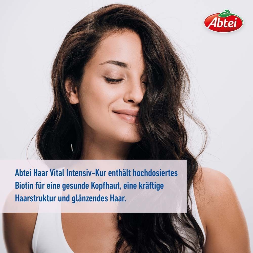 Frau mit langen, gewellten Haaren. Text: Abtei Haar Vital Intensiv-Kur enthält hochdosiertes Biotin für gesunde Kopfhaut, kräftige Haarstruktur und glänzendes Haar.
