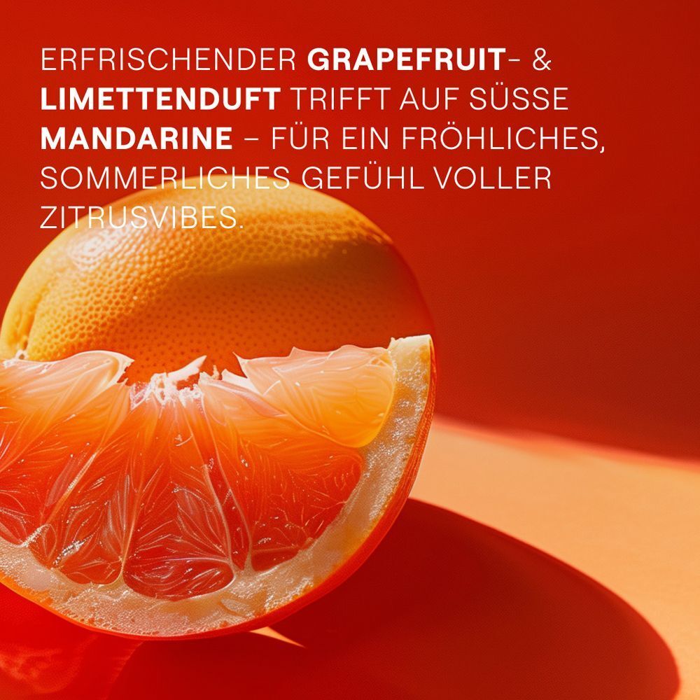 Nahaufnahme einer Grapefruit-Hälfte. Roter Hintergrund. Text: Erfrischender Grapefruit- & Limettenduft trifft auf Mandarine.