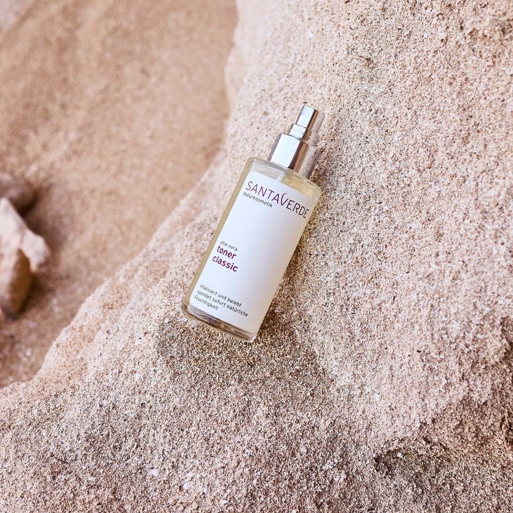 SANTAVERDE Toner Classic auf Sandstein. Klare Flüssigkeit, weißes Etikett, silberner Sprühkopf. Text: Aloe Vera, Toner Classic.