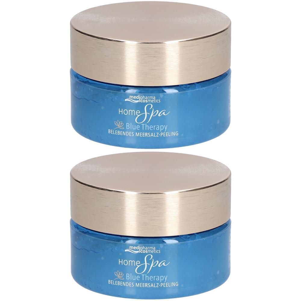 Zwei blaue Tiegel mit goldenen Deckeln. Auf den Tiegeln steht "Home Spa Blue Therapy Belebtes Meersalz-Peeling".