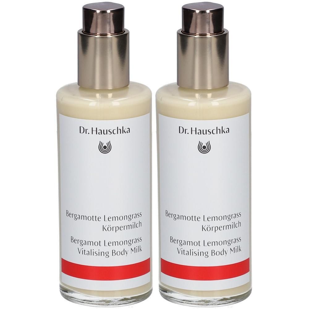 Zwei Flaschen Körperlotion. Aufschrift: Dr. Hauschka, Bergamotte Lemongrass Körpermilch, Vitalising Body Milk. Flaschen mit silbernen Pumpaufsätzen.