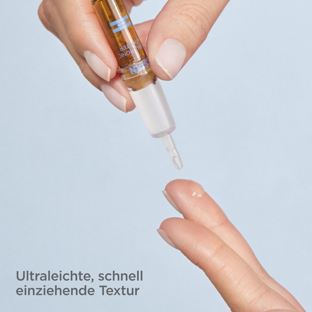 Hand tropft Flüssigkeit aus einer Ampulle ISDINCEUTICS® Hyaluronic Booster auf einen Finger.
