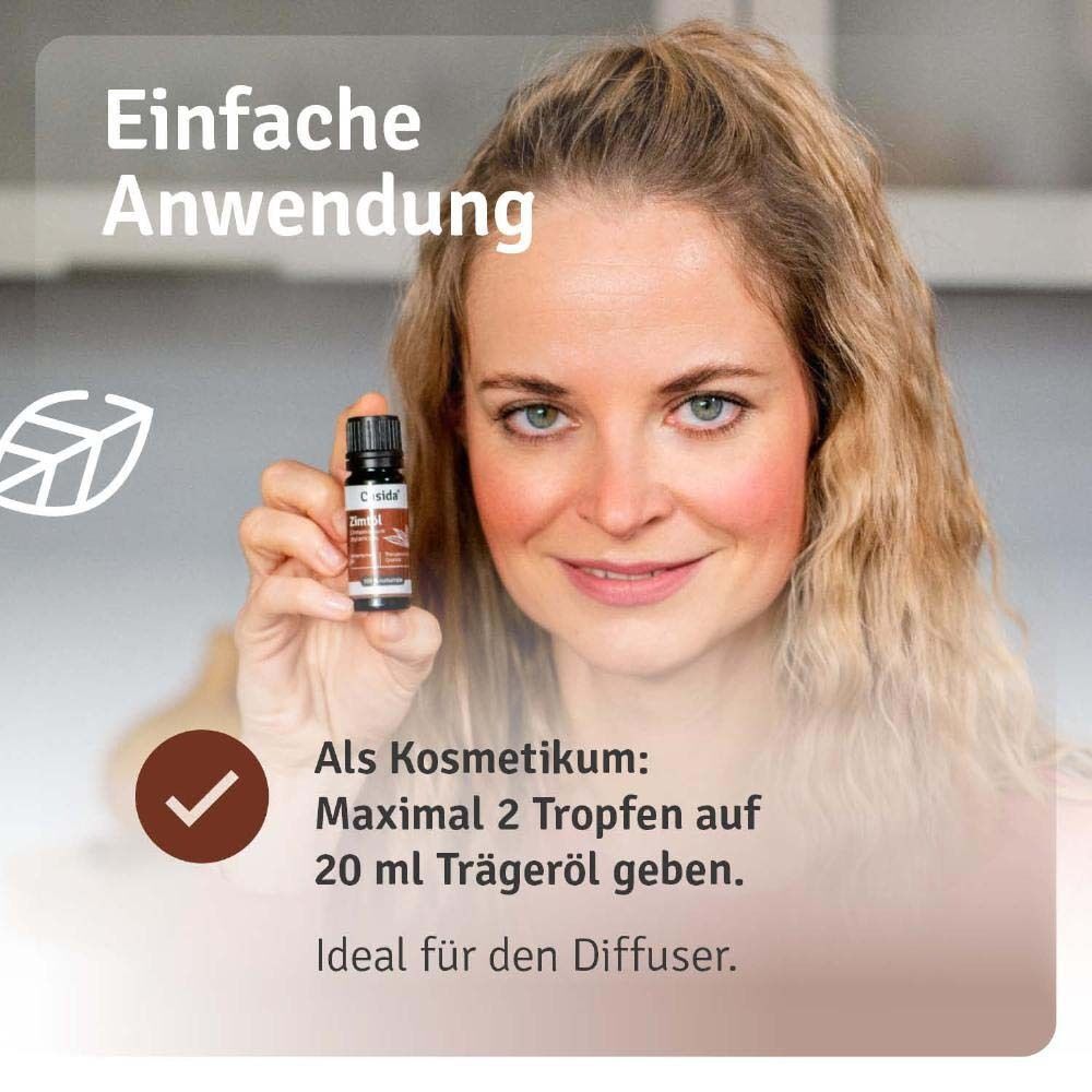 Eine Frau hält eine Flasche Casida Zimtöl. Text mit Anwendungshinweisen: Kosmetikum, maximal 2 Tropfen auf 20 ml Trägeröl.