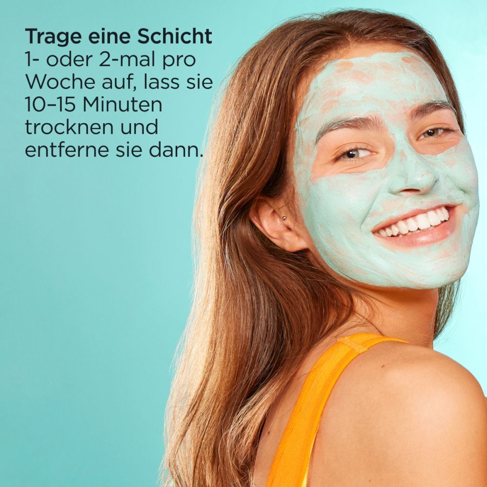 Frau mit grüner Gesichtsmaske. Text: Trage eine Schicht 1- oder 2-mal pro Woche auf, lass sie 10-15 Minuten trocknen und entferne sie dann.