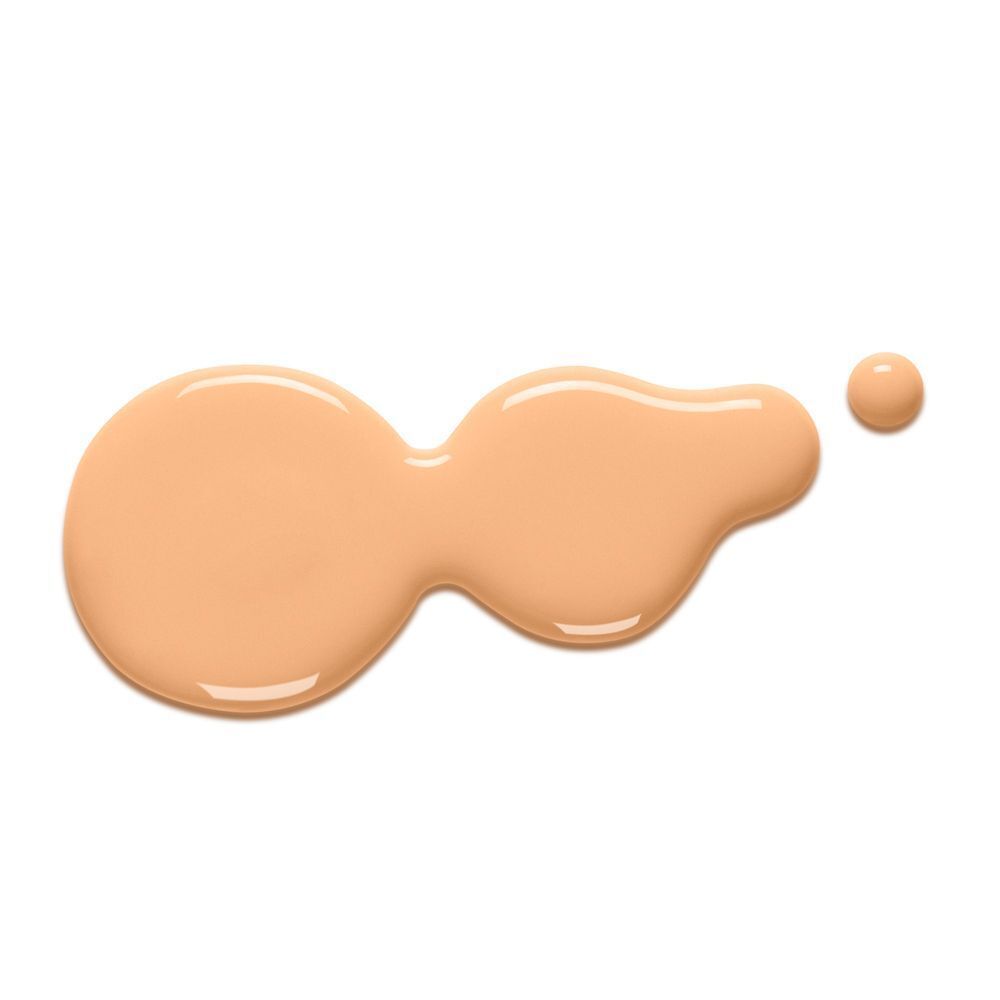 Beige Flüssigkeit auf weißem Hintergrund. Tropfen mit unregelmäßiger Form.