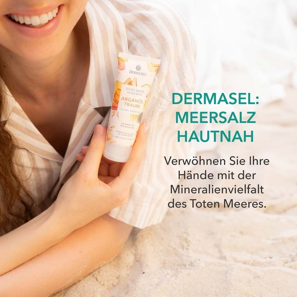 Frau hält Tube Handcreme. Text: DERMASEL: Meersalz hautnah. Verwöhnen Sie Ihre Hände mit der Mineralienvielfalt des Toten Meeres.