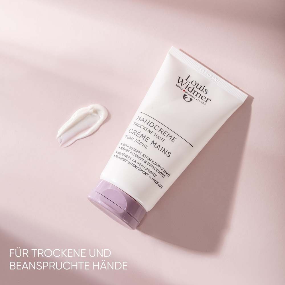 Handcreme-Tube, weiß mit lila Verschluss. Aufschrift: Handcreme, trockene Haut, Crème Mains, Peau sèche. Klecks Creme daneben. Marke: Louis Widmer.