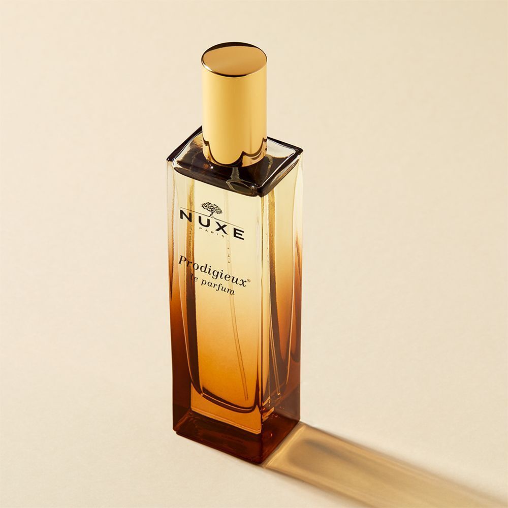 Rechteckiger Glasflakon mit goldener Kappe. Aufschrift: NUXE Paris, Prodigieux le parfum. Farbverlauf.