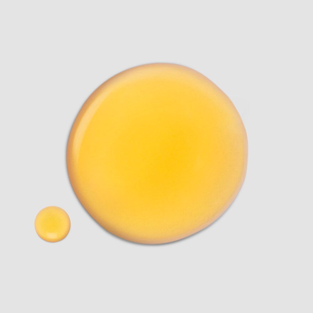 Zwei gelbe Flüssigkeitstropfen auf grauem Hintergrund. Ein großer und ein kleiner Tropfen.