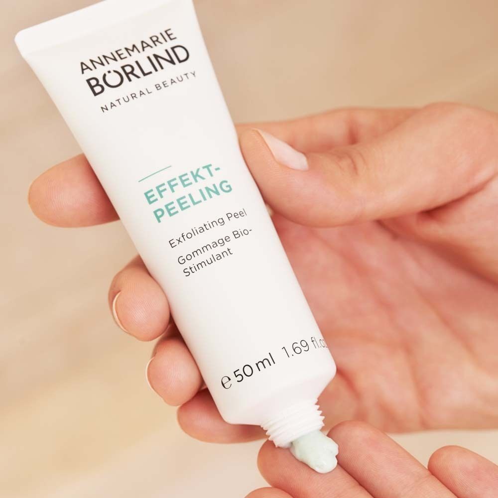 Hand hält Tube ANNEMARIE BÖRLIND EFFEKT-PEELING, Peeling wird auf Finger aufgetragen.