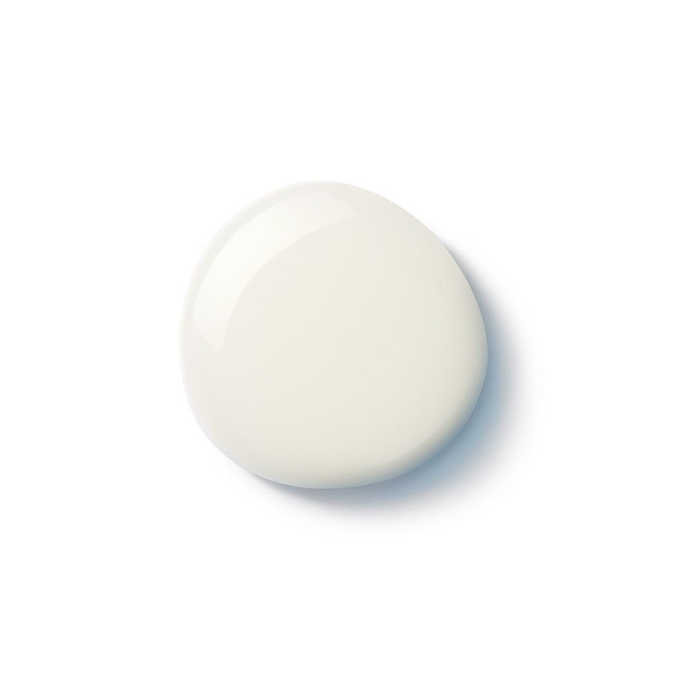 Ein Tropfen cremefarbene Flüssigkeit auf weißem Hintergrund. Glänzende Oberfläche.