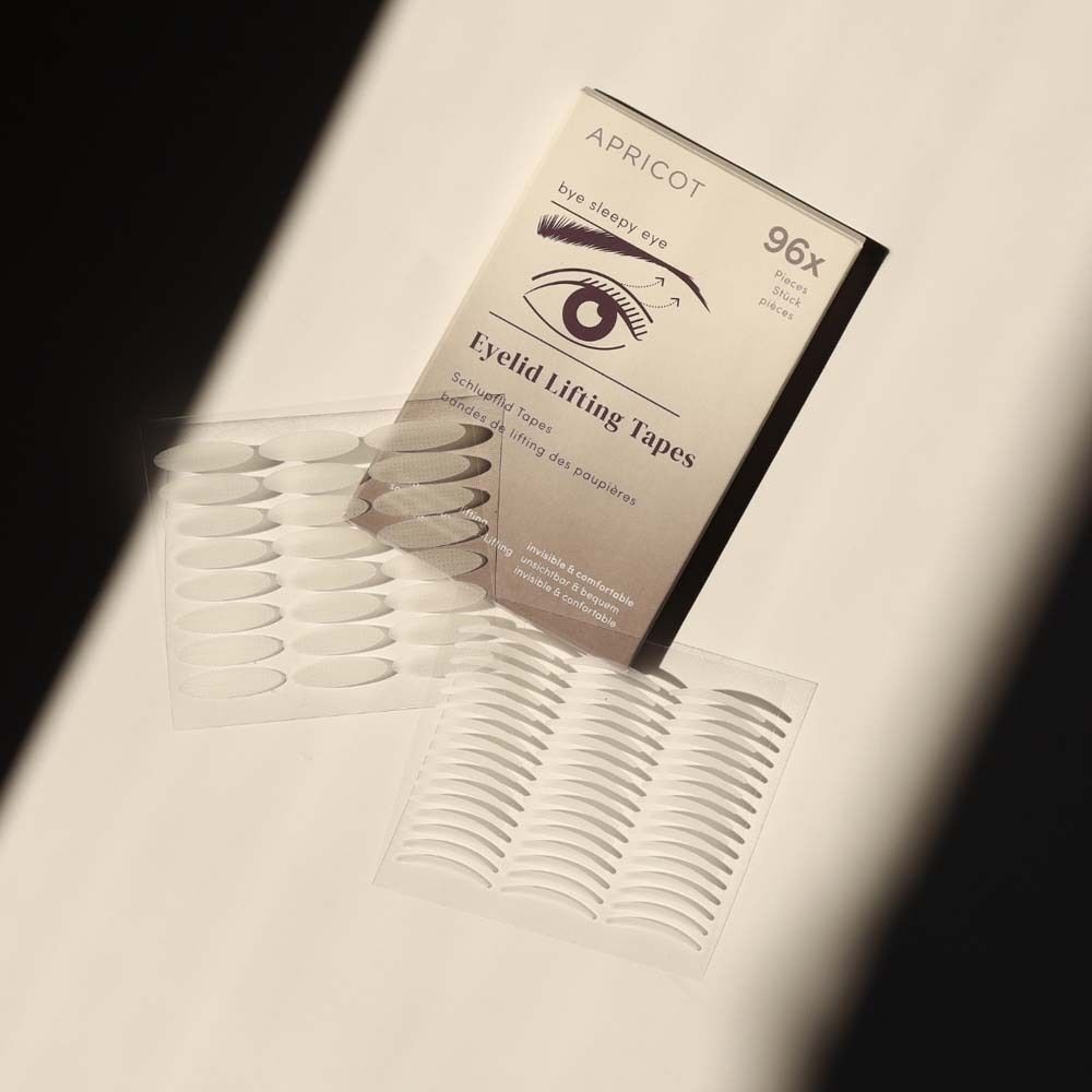 APRICOT Eyelid Lifting Tapes und Verpackung. Weiße Tapes auf transparentem Trägermaterial. Verpackung mit Produktinformationen.