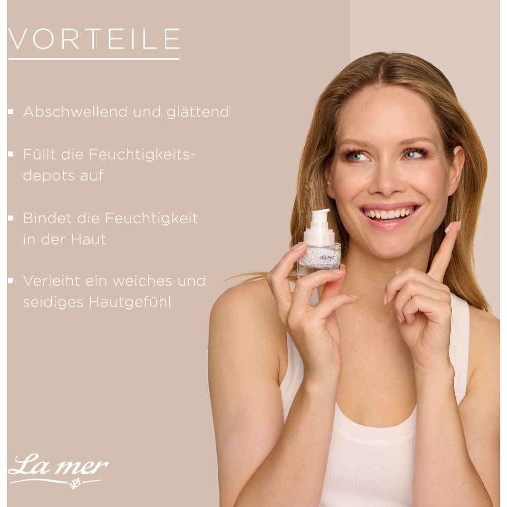 Frau hält La mer Ultra Booster Premium Effect Pearls Auge. Vorteile: Abschwellend, glättend, feuchtigkeitsspendend, weiches Hautgefühl.